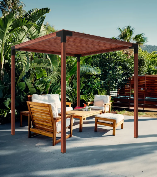 A wooden pergola with a couch and chairs underneath it