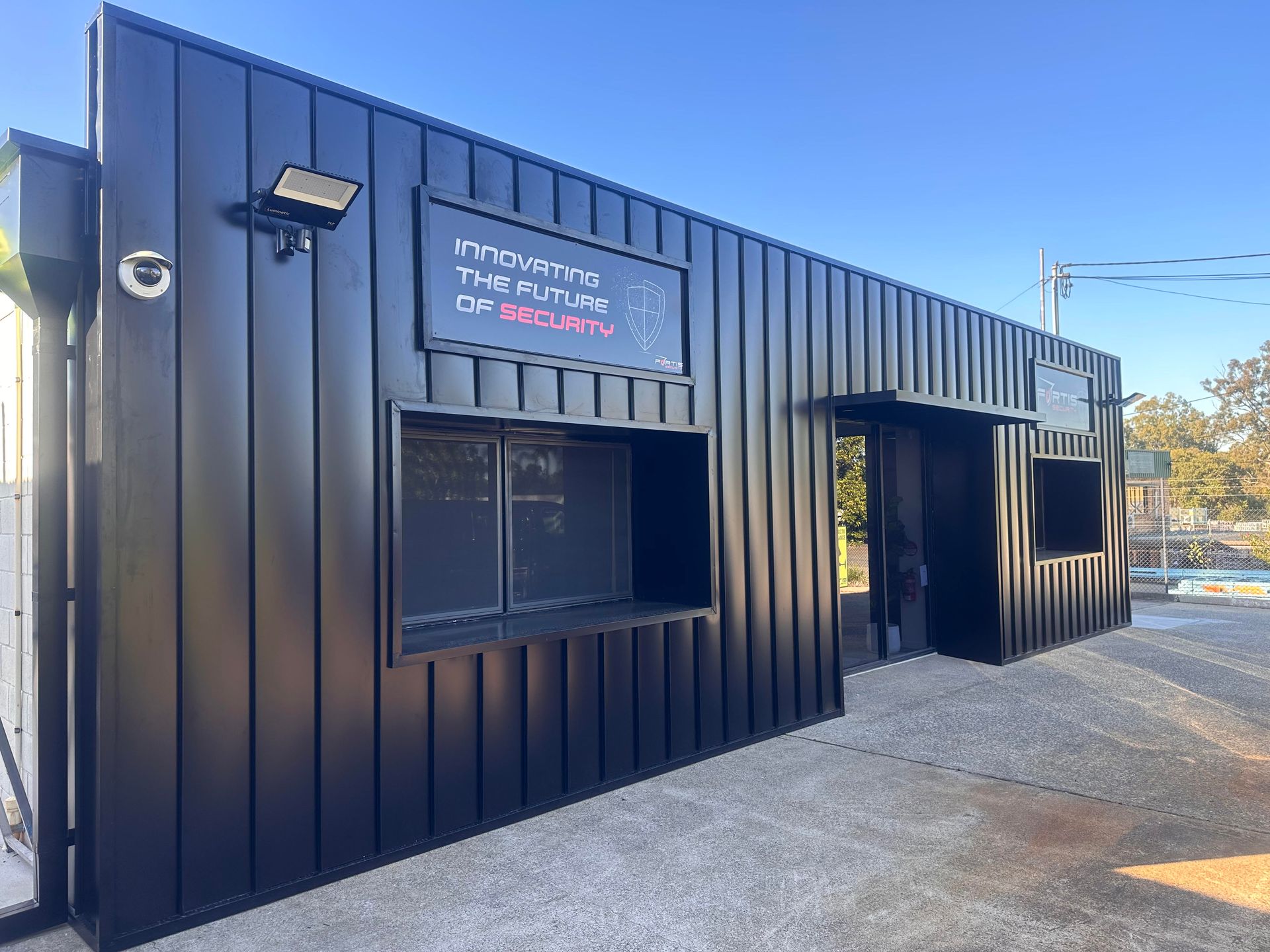 A black building with a sign on the side that says Fortis Security