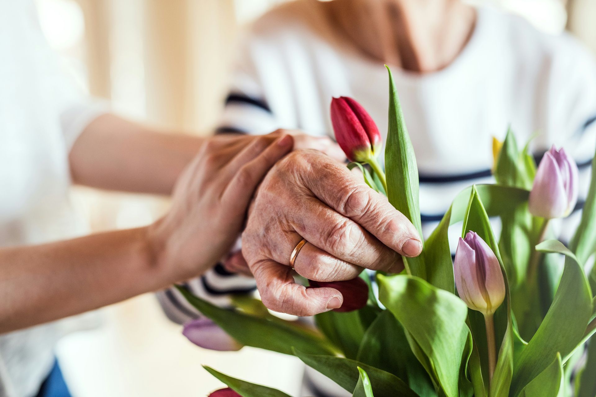 A man and a woman are standing next to each other in a room . the woman is holding the keys to the house.