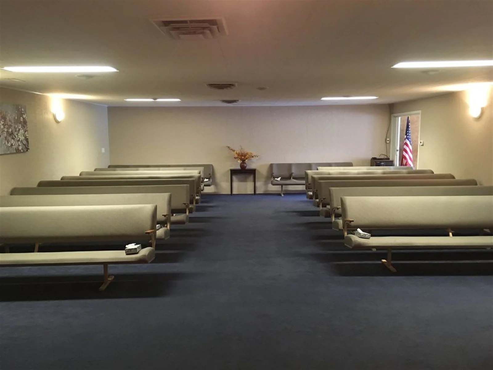 A row of benches in a room with a blue carpet