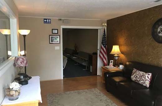 A living room with a couch , lamp , and american flag.