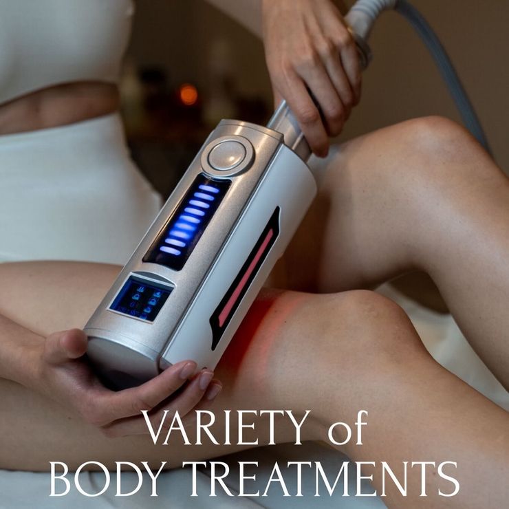 Person using a silver device with blue and red lights on a leg for body treatment. Text: Variety of Body Treatments.