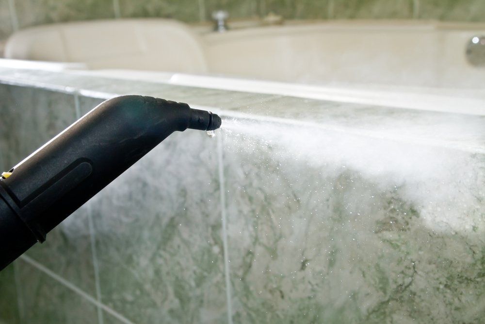 Steam Cleaner Nozzle Spraying Steam onto Green Tiled Bathroom — Clean Coast Carpet Cleaning in Port Stephens, NSW