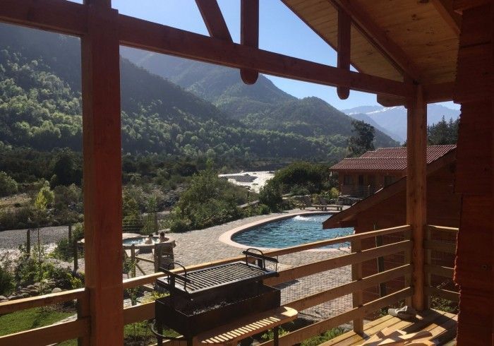 Vista desde el balcón de la piscina de un complejo de montaña y del valle al atardecer.
