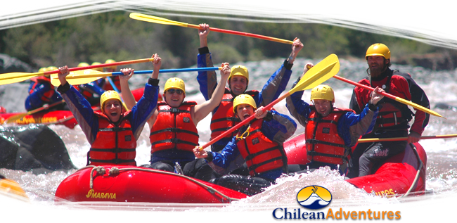 Un grupo de rafting con chalecos salvavidas rojos rema a través de aguas bravas con un guía frente a una cascada.