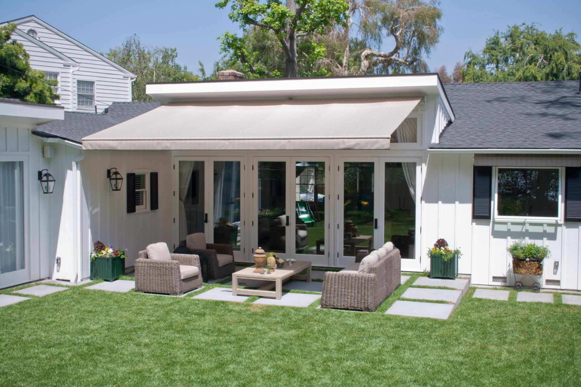 A white house with a patio area in front of it.