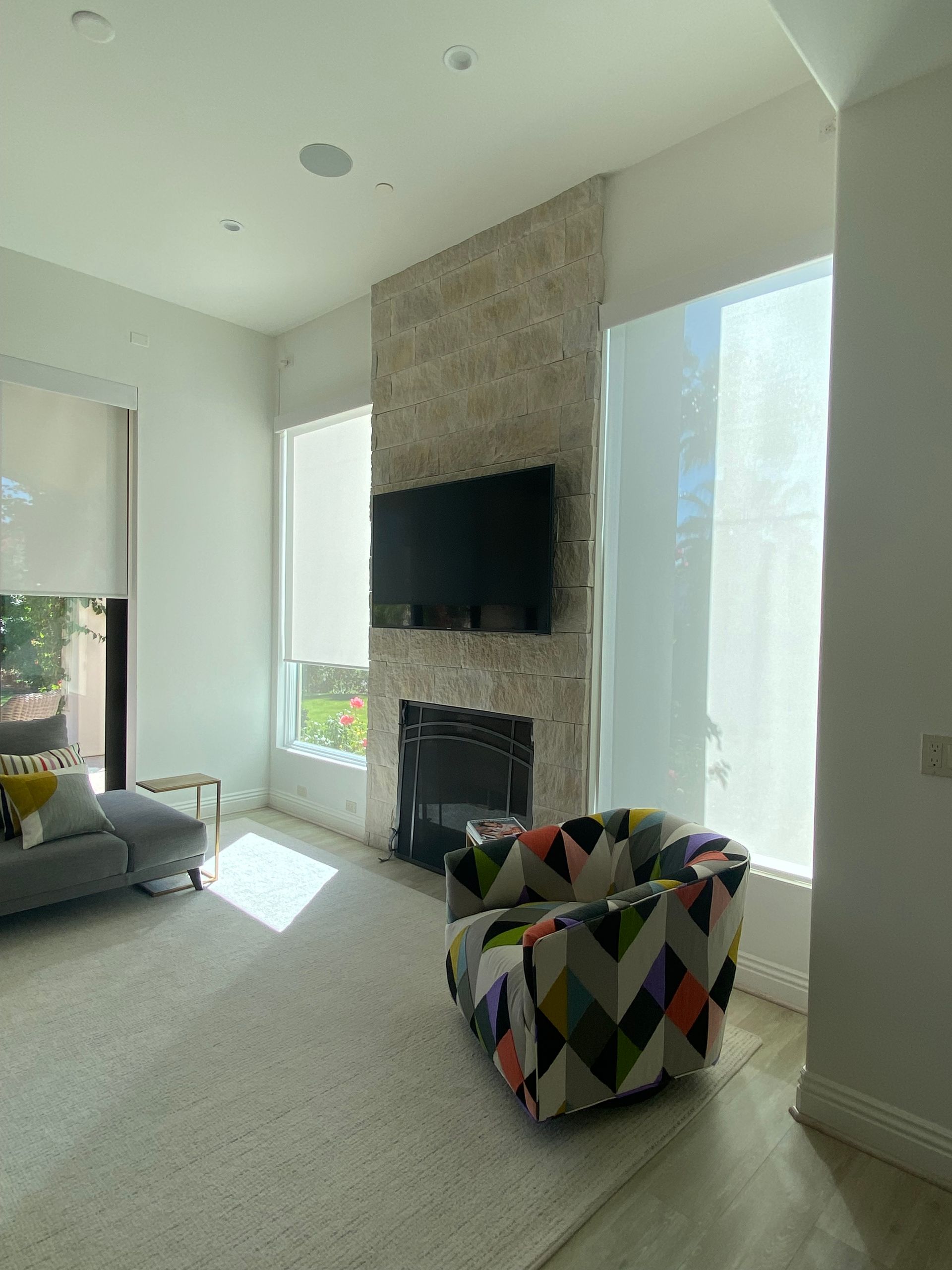 A living room with a fireplace , chair , couch and television.