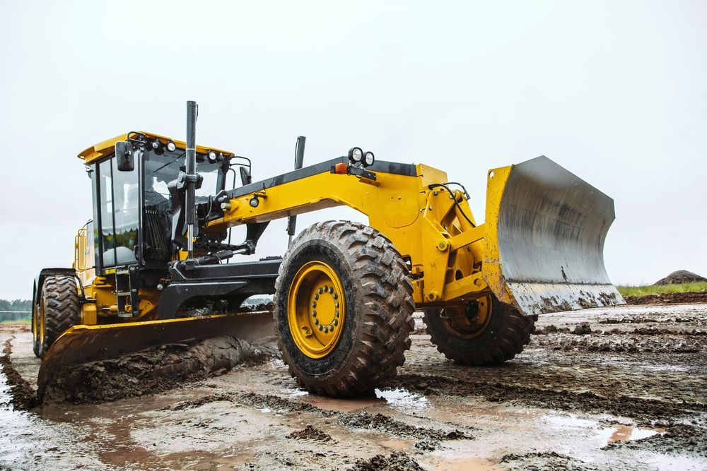 Yellow Motor Grader Smoothing Wet Dirt Road — Shantui QLD in Kingsthorpe, QLD