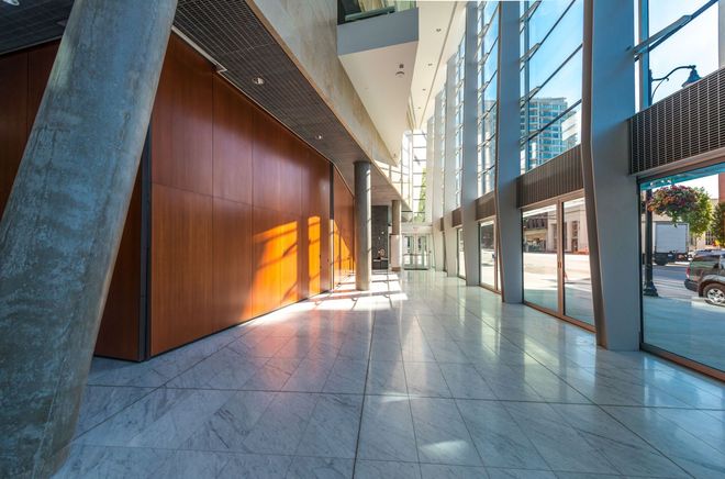 A long hallway with a lot of windows and a wooden wall