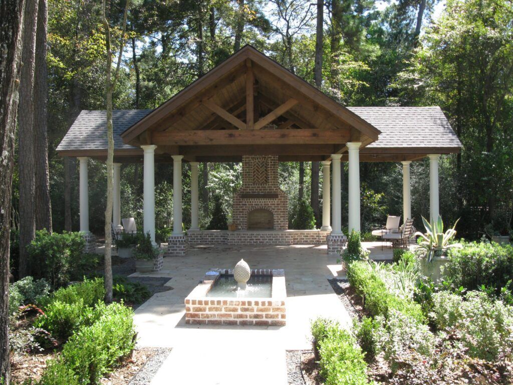 A gazebo with a fireplace in the middle of the woods