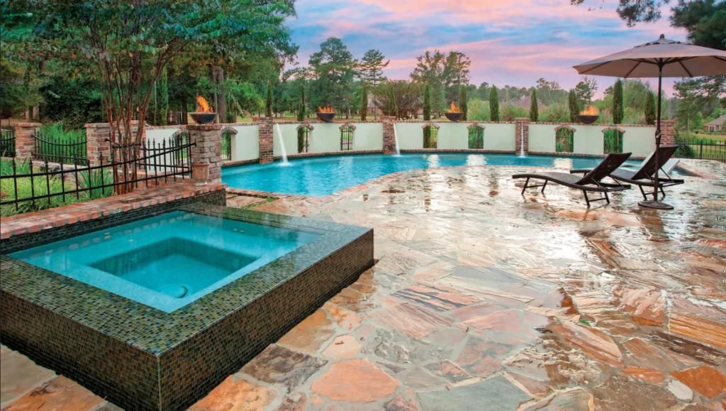 A large swimming pool with a hot tub in the middle of it