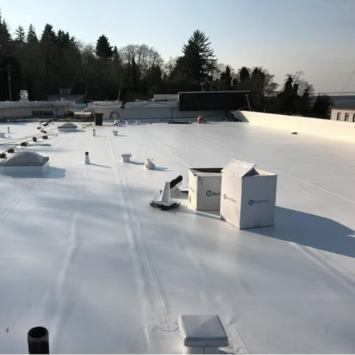 Duro-Last Single-Ply Membrane Roof System on a flat rooftop with vents and boxes, trees in the background under a clear sky