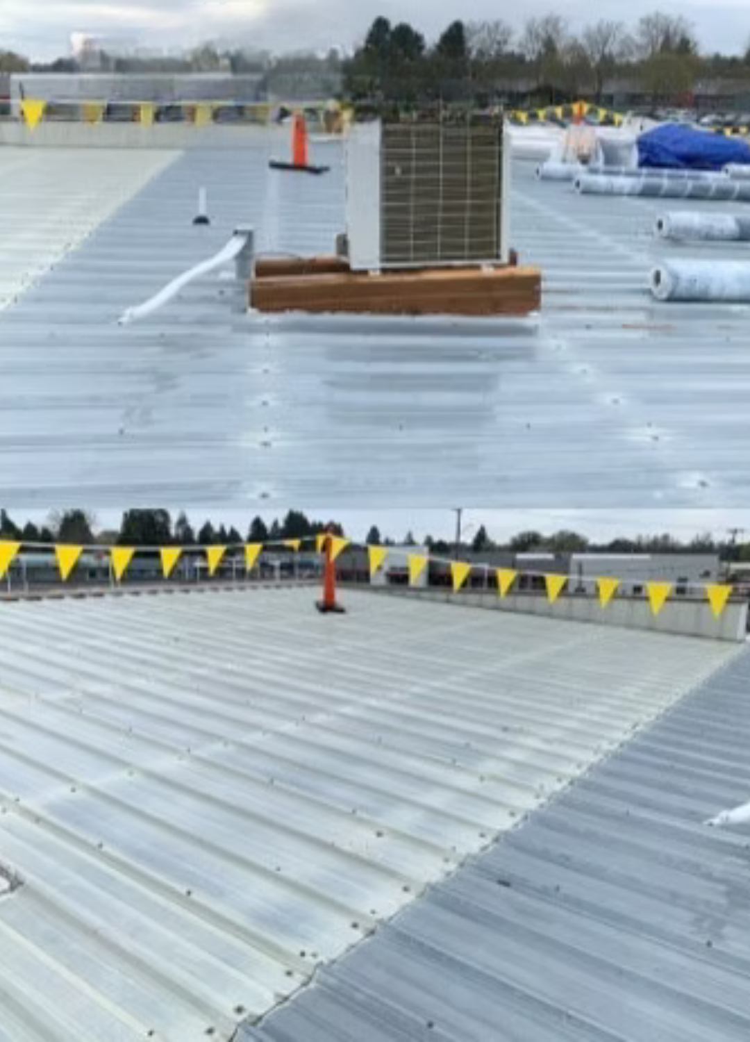 Rooftop with silver metal panels, HVAC units, and yellow safety flags under an overcast sky