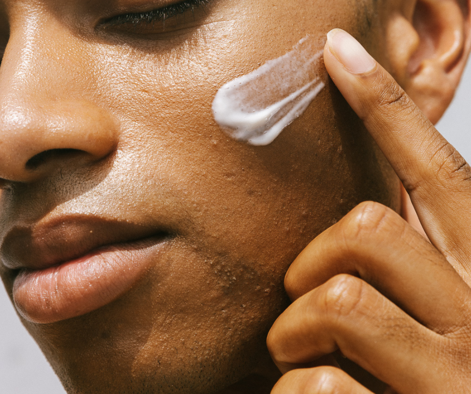 Person applying white cream to their face.