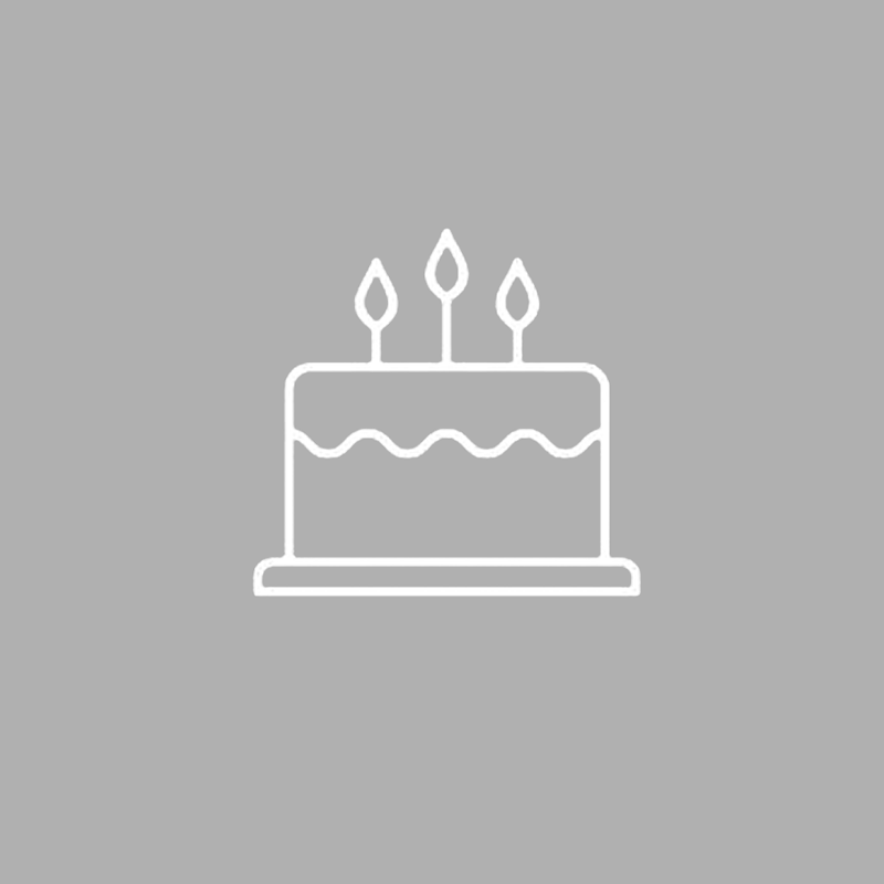 White line drawing of a birthday cake with three lit candles on a gray background.