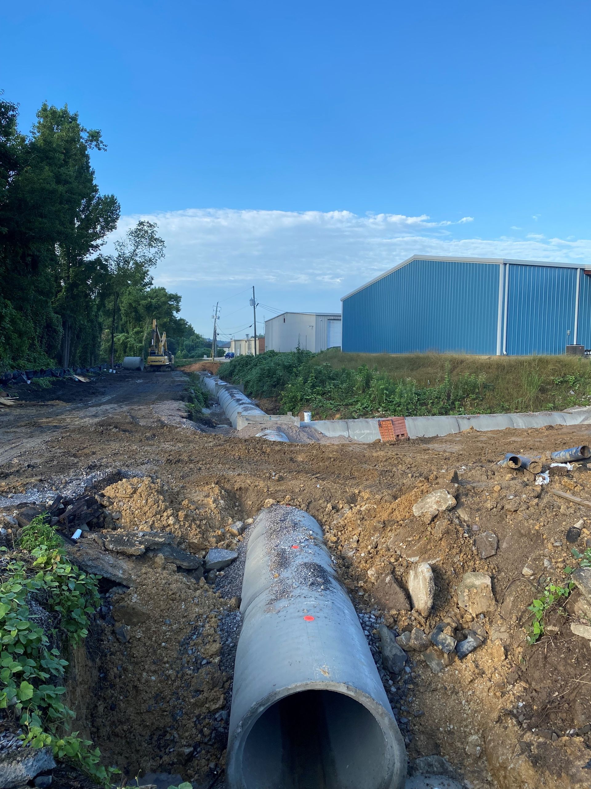 A large concrete pipe is sitting in the middle of a dirt field.