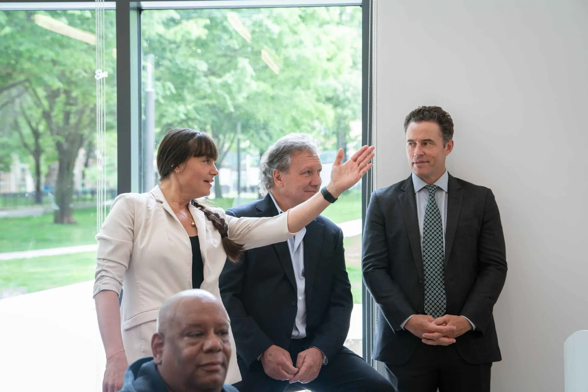 A group of people are standing next to each other in front of a window.