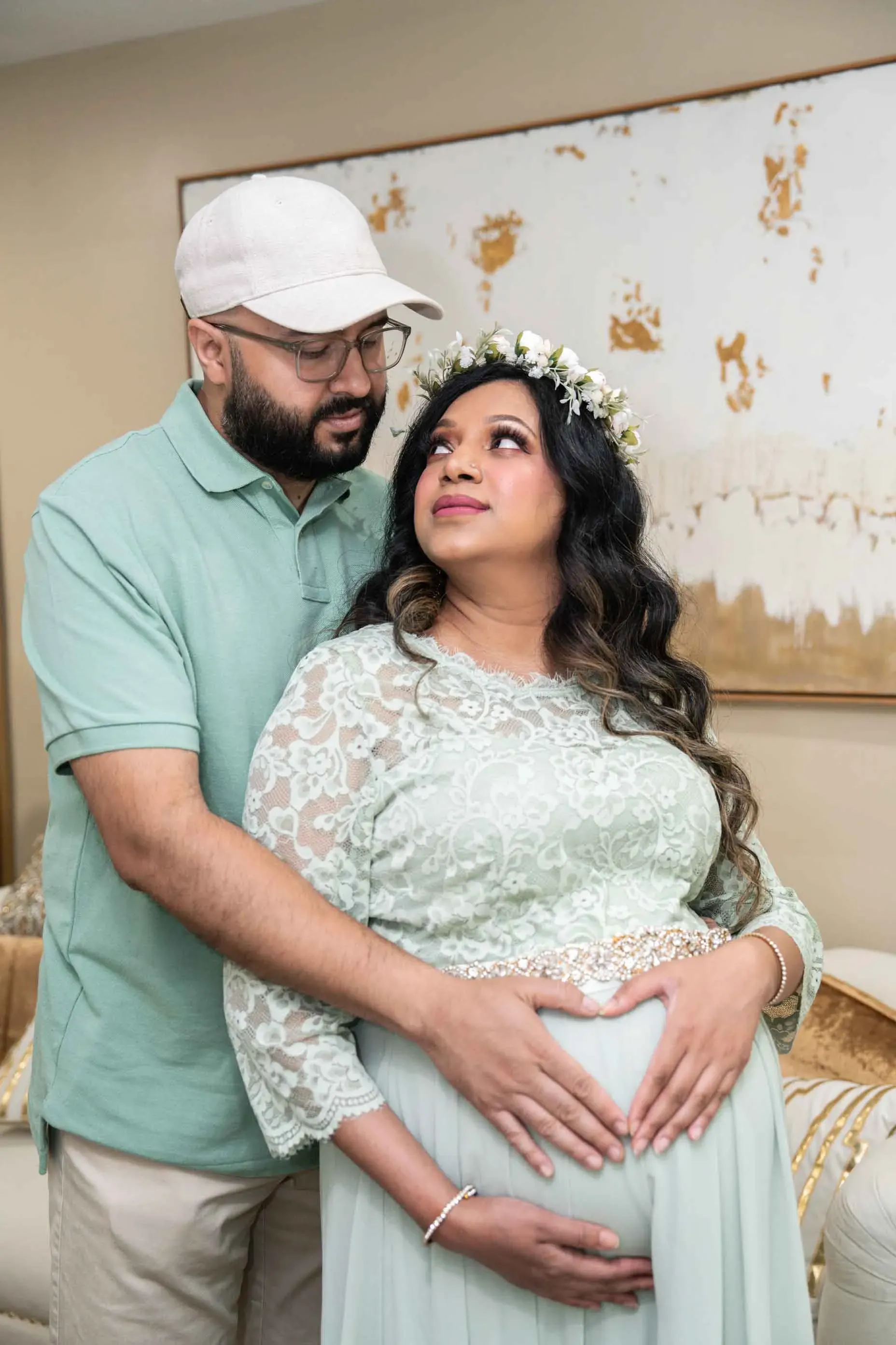 A man and a pregnant woman are standing next to each other in a living room.