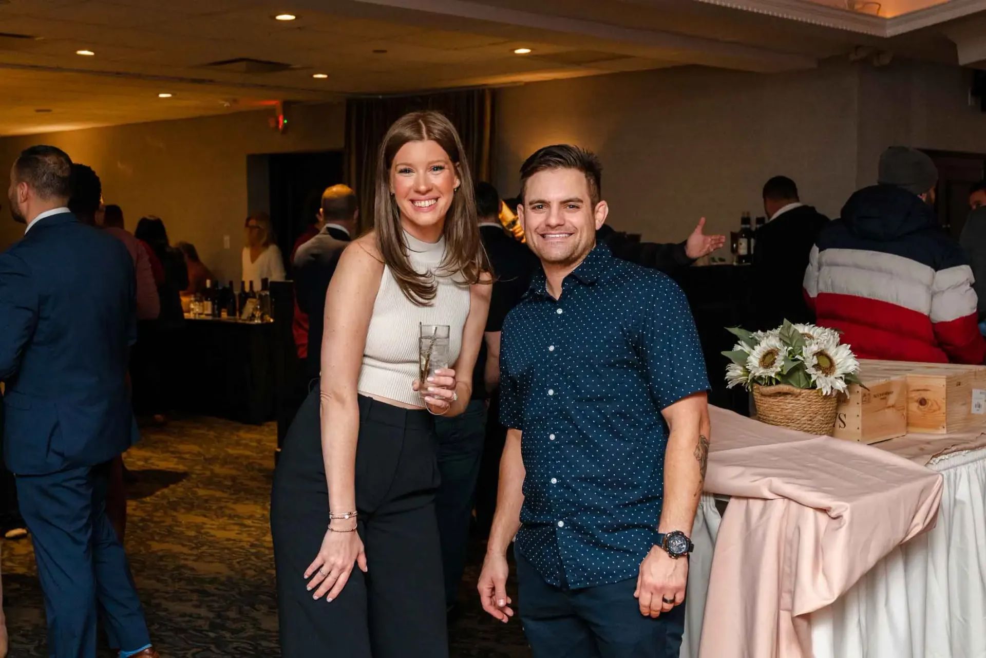 A man and a woman are posing for a picture in a room at a party.