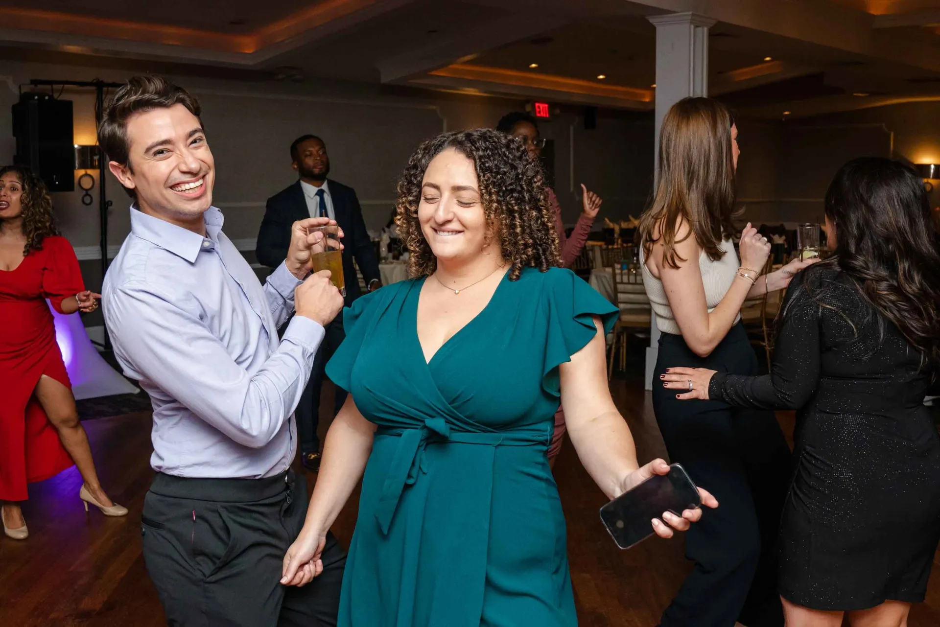 A group of people are dancing on a dance floor at a party.