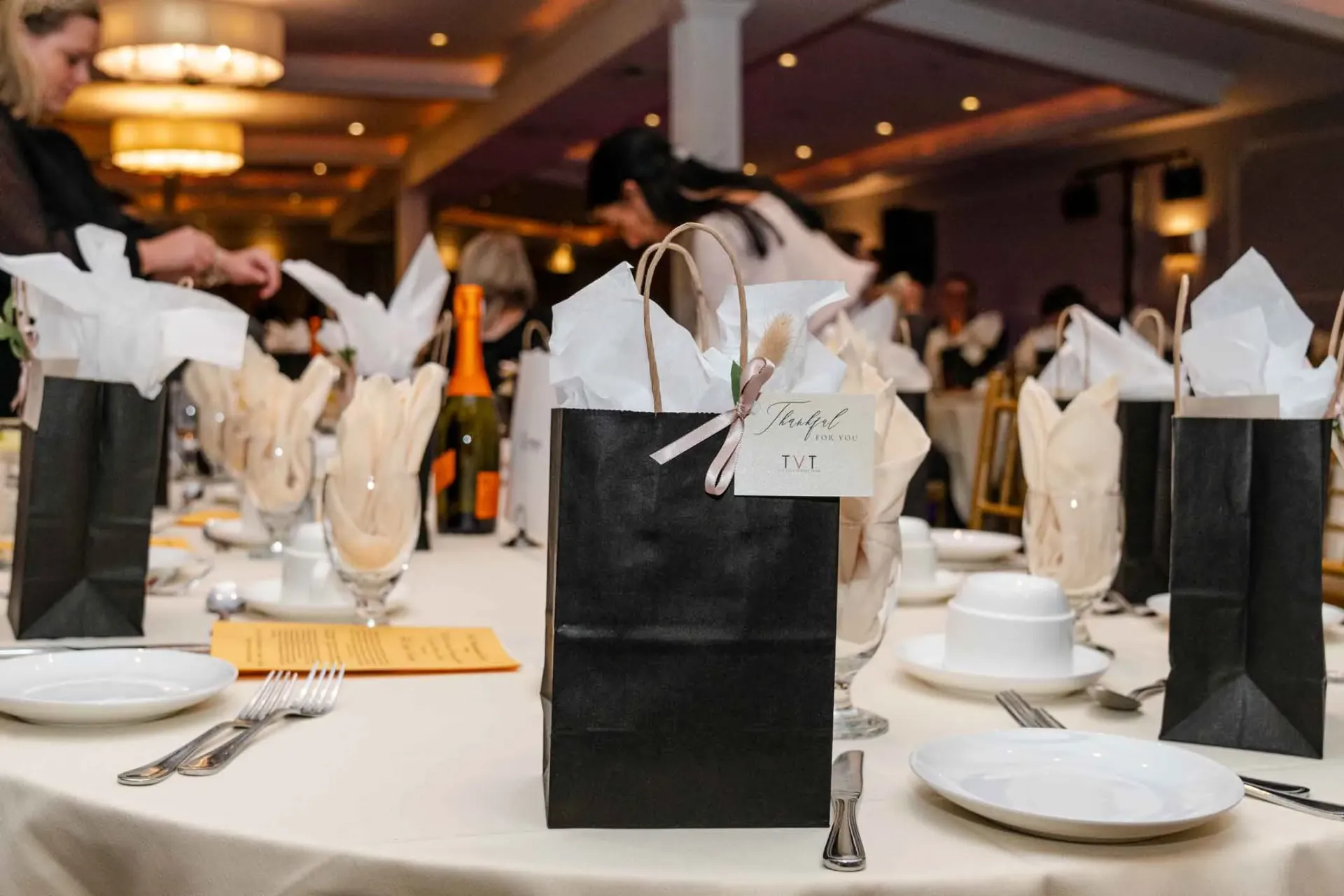 A table set for a party with black bags on it.