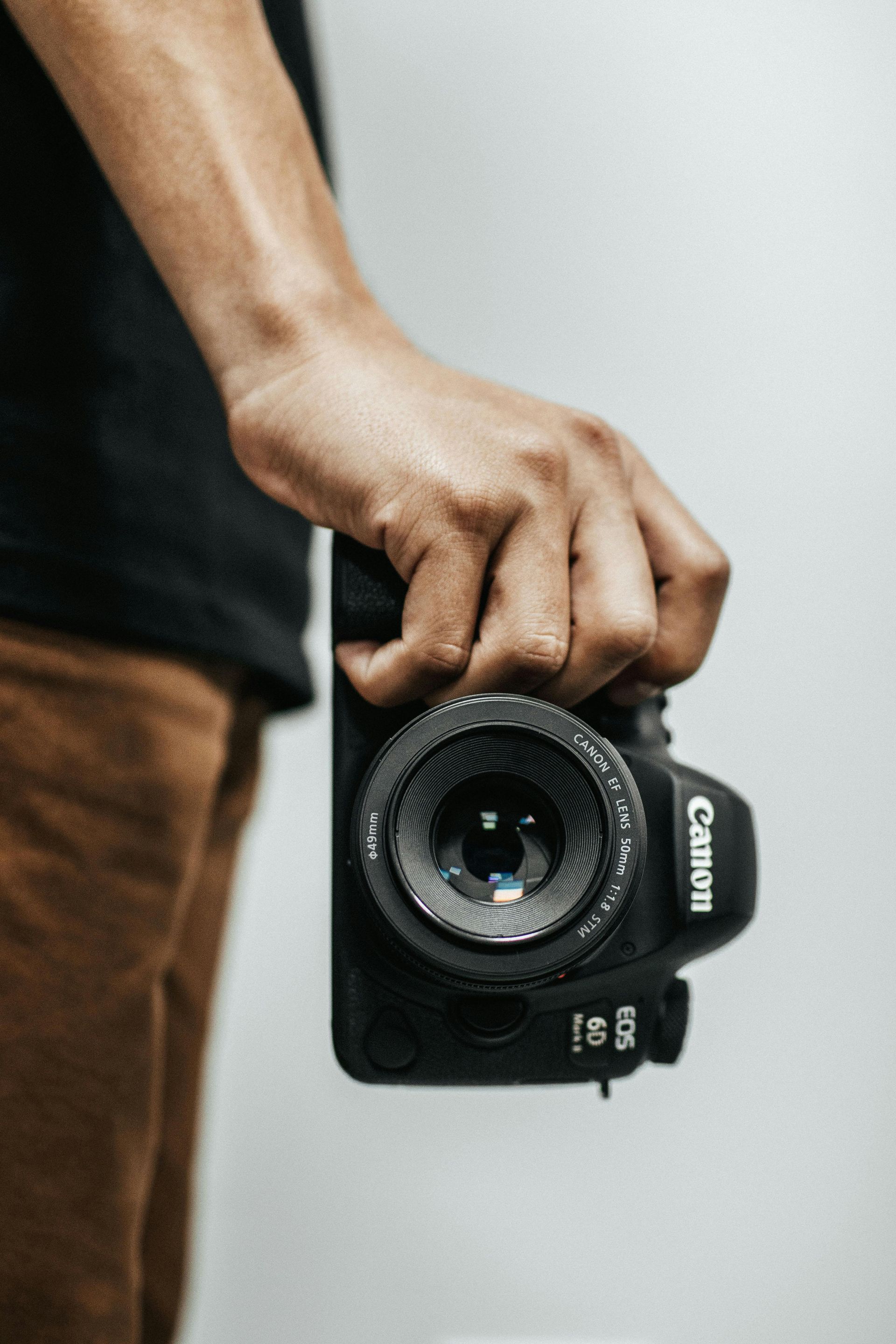 A person is holding a canon camera in their hand.