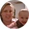 Smiling adult and child close together, both in pink, with a blurred outdoor background