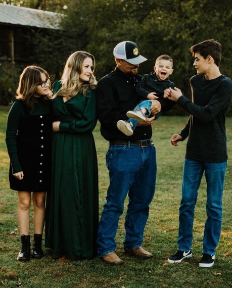 A family is posing for a picture in a field.