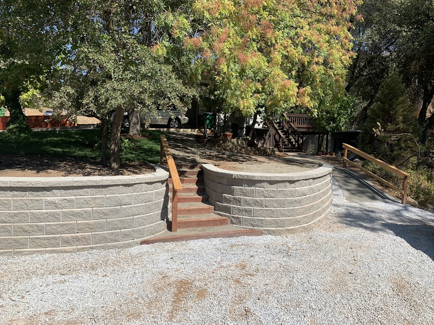 A brick wall with stairs leading up to it in a park.