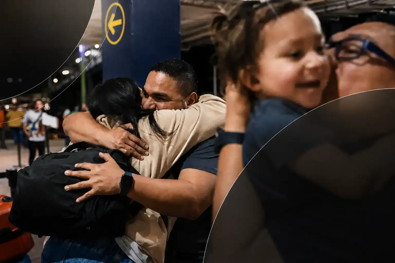 People embracing in a crowded outdoor nighttime scene, with a child smiling in the foreground