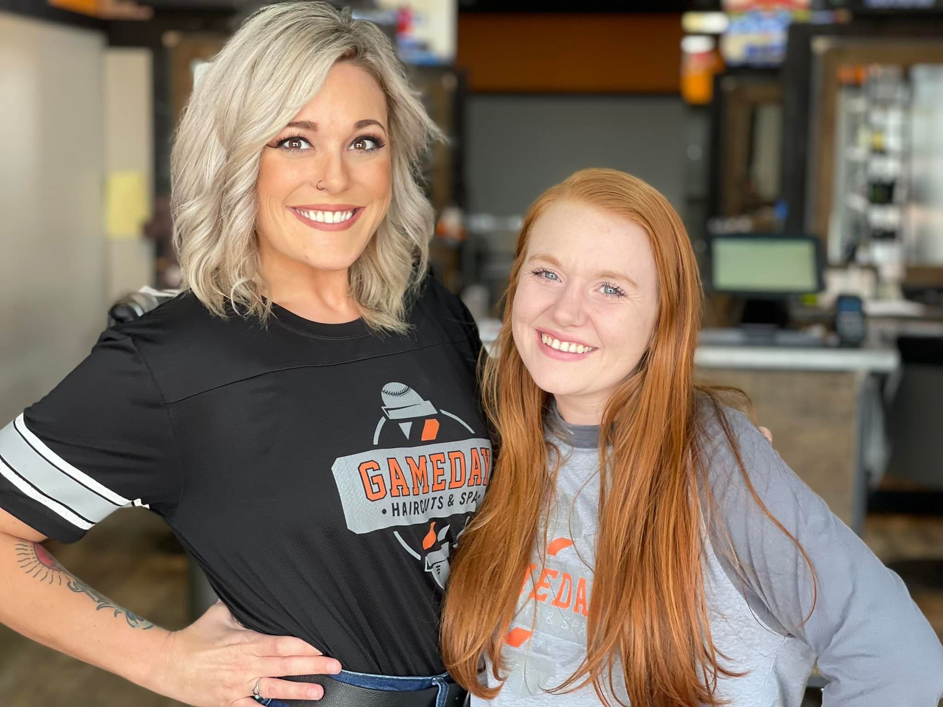 Two women smiling, posing inside a business.