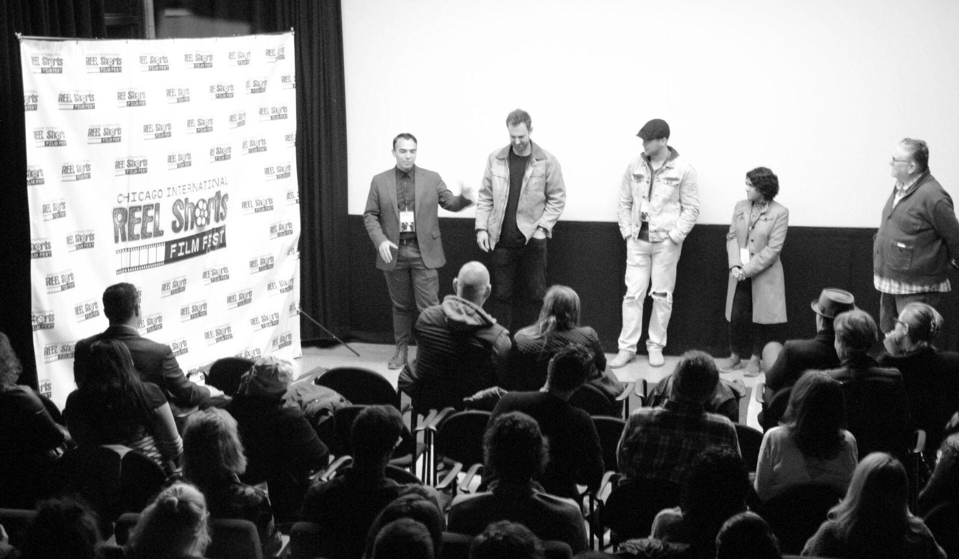 Panel of people on stage, talking to an audience at a film festival.