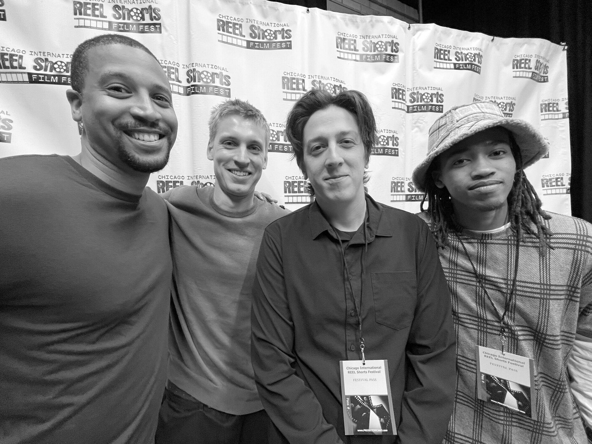 Four people smiling at a film festival. Black and white photo.