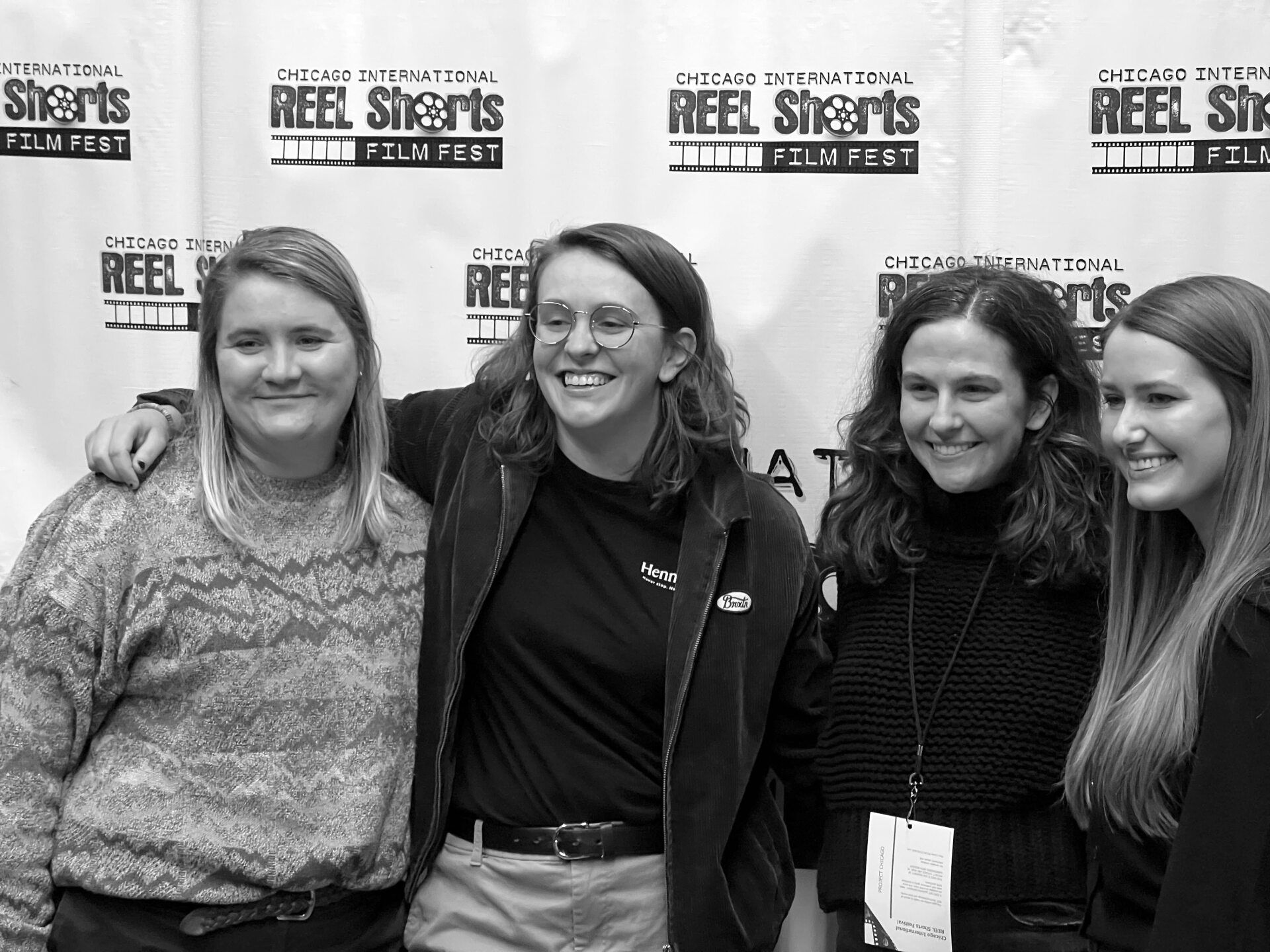 Four women smiling, posing at the Chicago Reel Shorts Film Fest. Black and white photo.