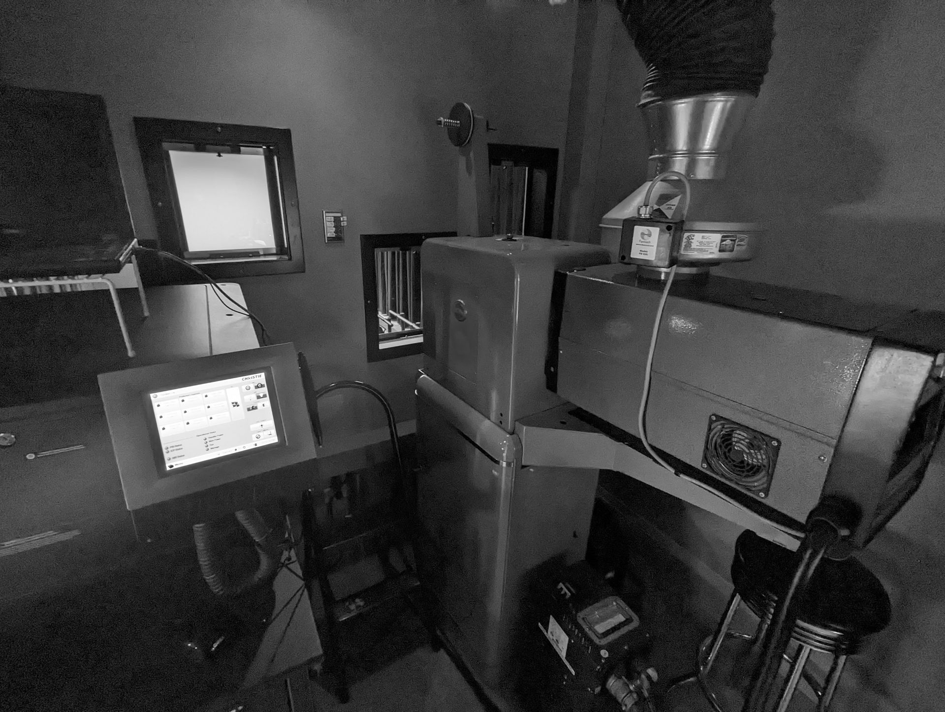 A gray-scale photo of a coffee roasting machine inside a small room.