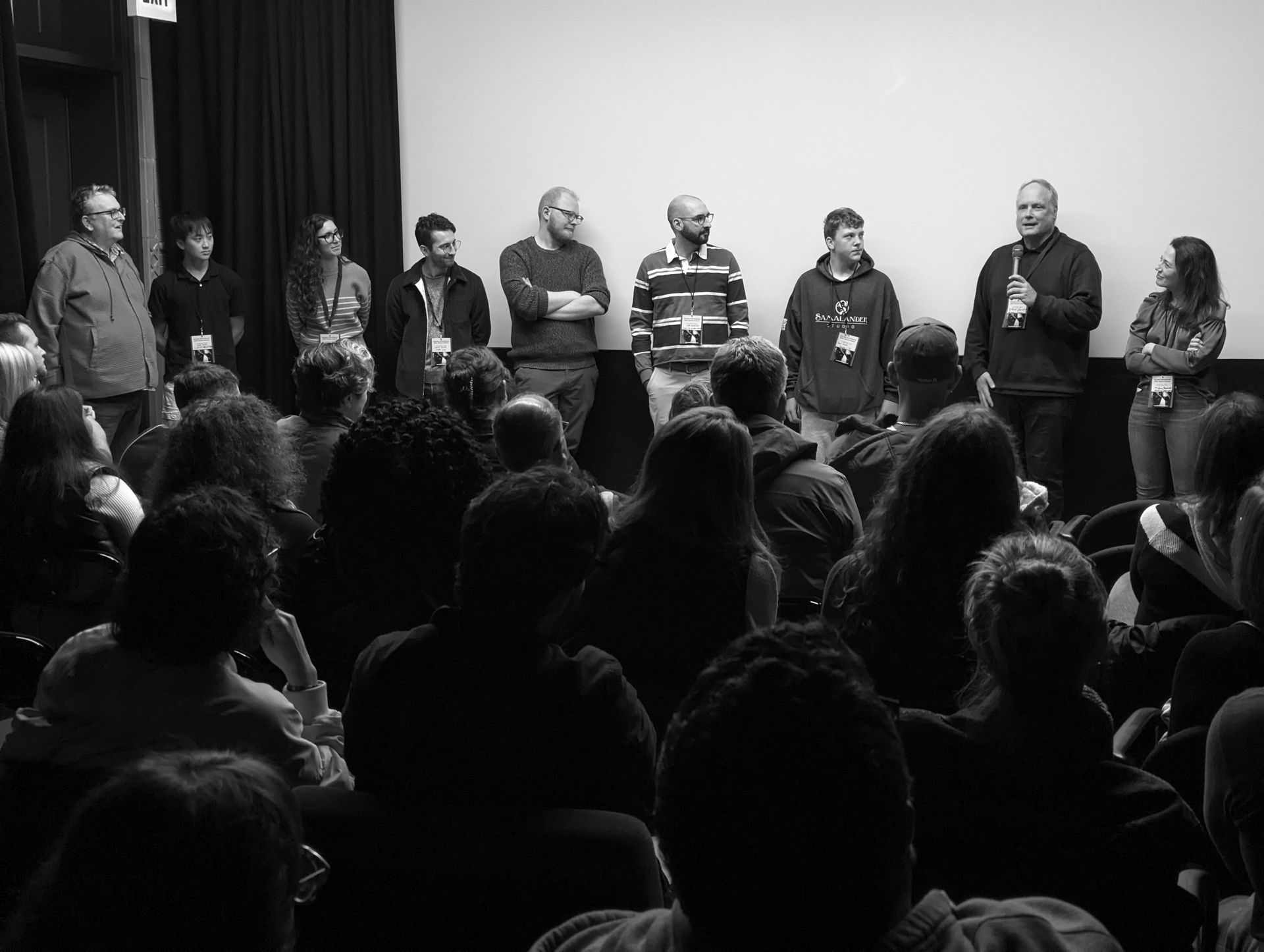 Panel of people standing before an audience, answering questions after a presentation.