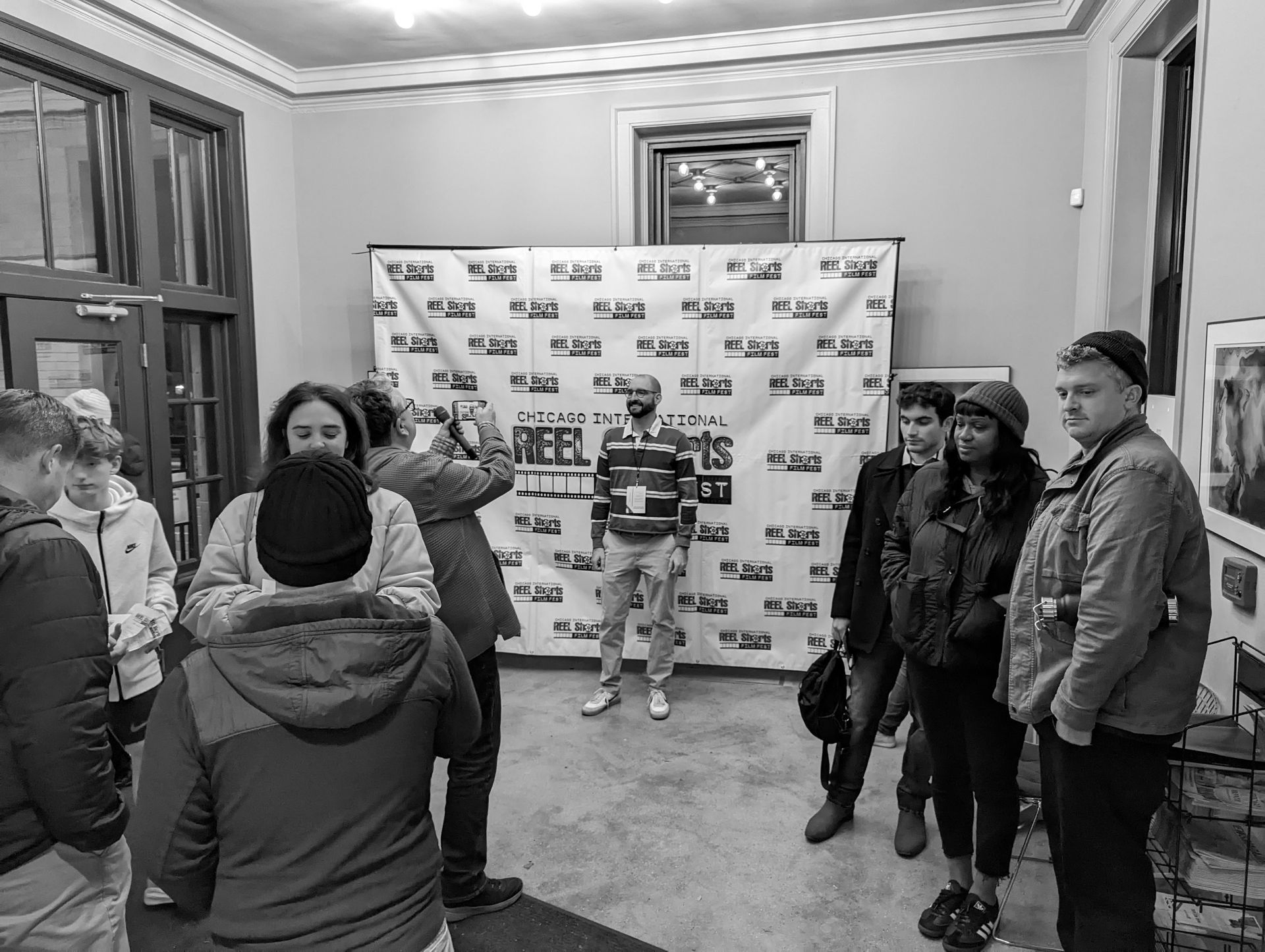 People gathered in a hall with a backdrop that says 