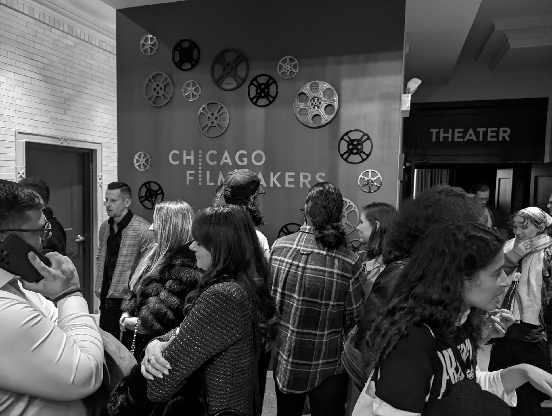 People gathered at the Chicago Filmmakers theater entrance; reel decorations, text, and a 