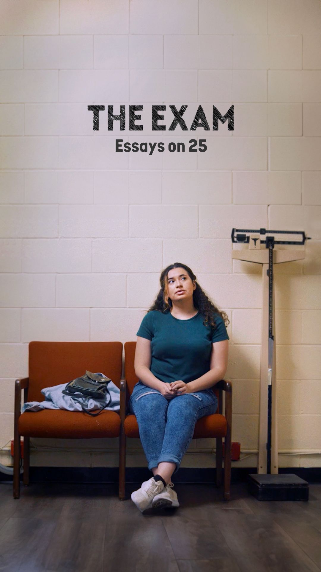 Woman sitting in a waiting room, looking up with concerned expression. Sign reads