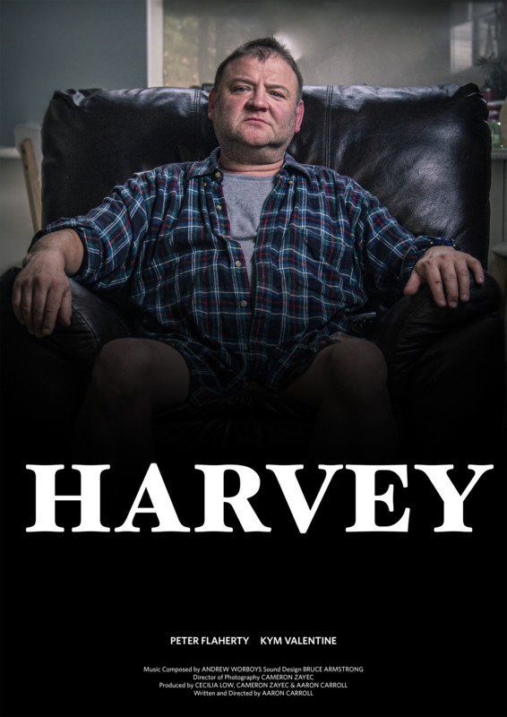 Man in plaid shirt sits in chair, staring forward. White text below: