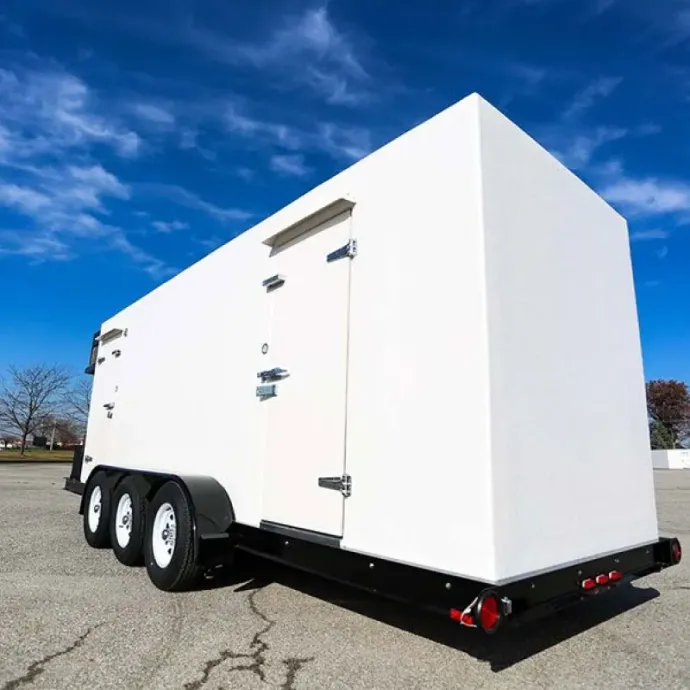 White enclosed cargo trailer with triple axles parked on pavement under a blue sky
