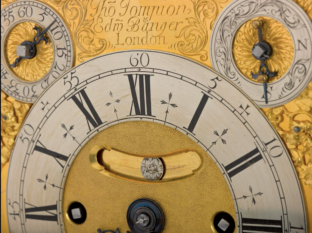 Quastel Associates Valuers | Close-up of an antique clock face with Roman numerals, two smaller dials, and engraved details.