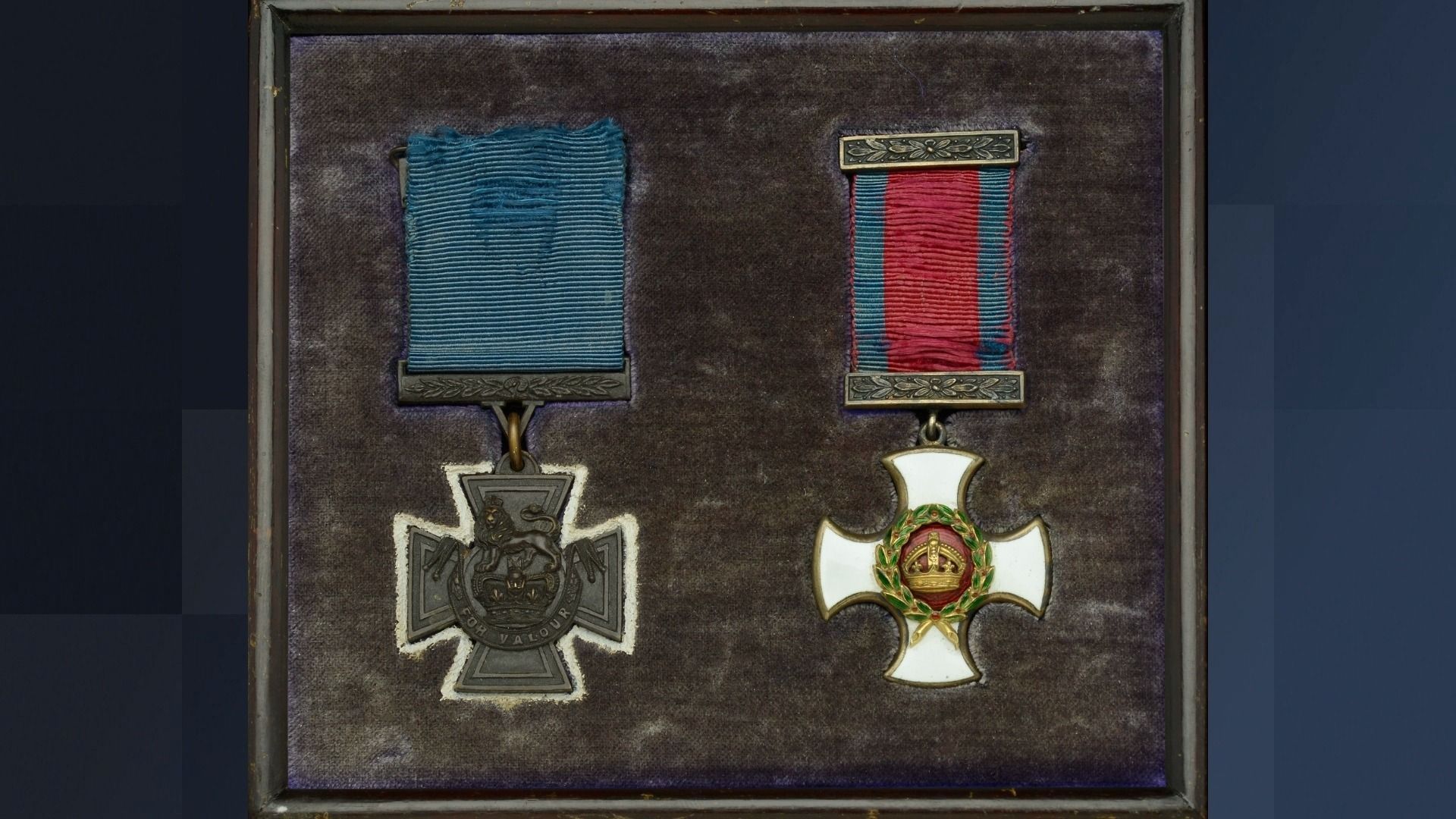 Quastel Associates Valuers | Two medals in a case: a dark cross with blue ribbon and a white cross with red ribbon.