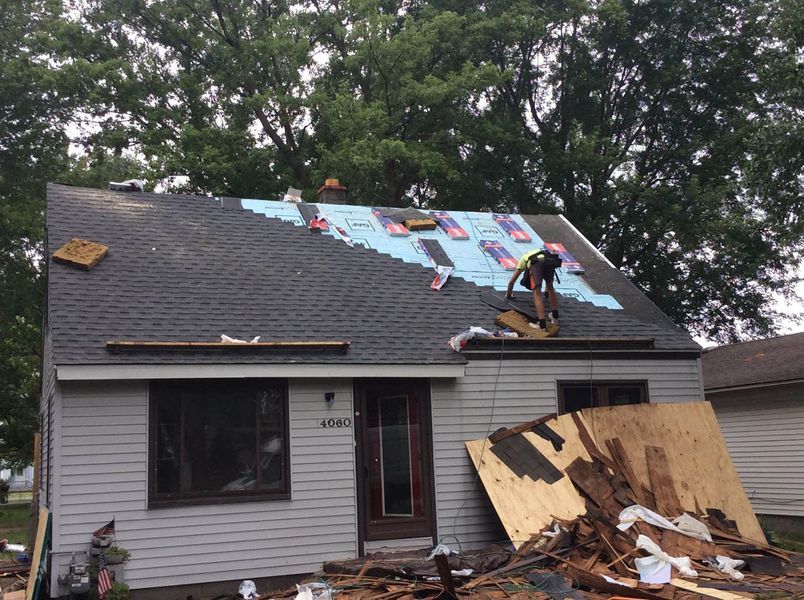 a man on a roof of a house. GenAlt