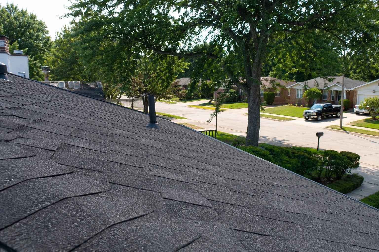 Realistic summer roof inspection on a suburban Michigan home with asphalt shingles in a residential