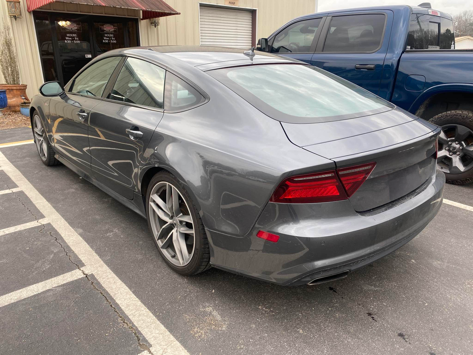 A gray audi a7 is parked in a parking lot next to a blue truck.  | Windham Bodyshop