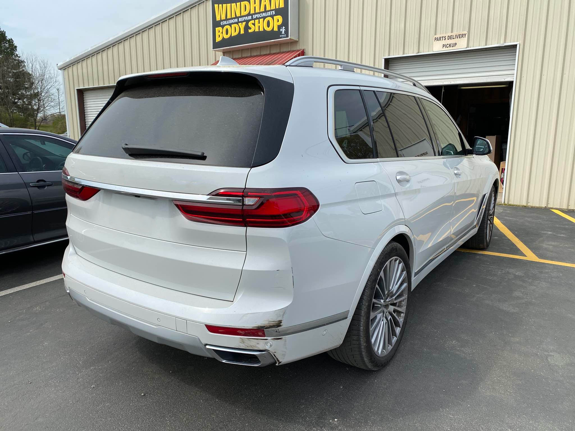 A white car is parked in front of a body shop.  | Windham Bodyshop