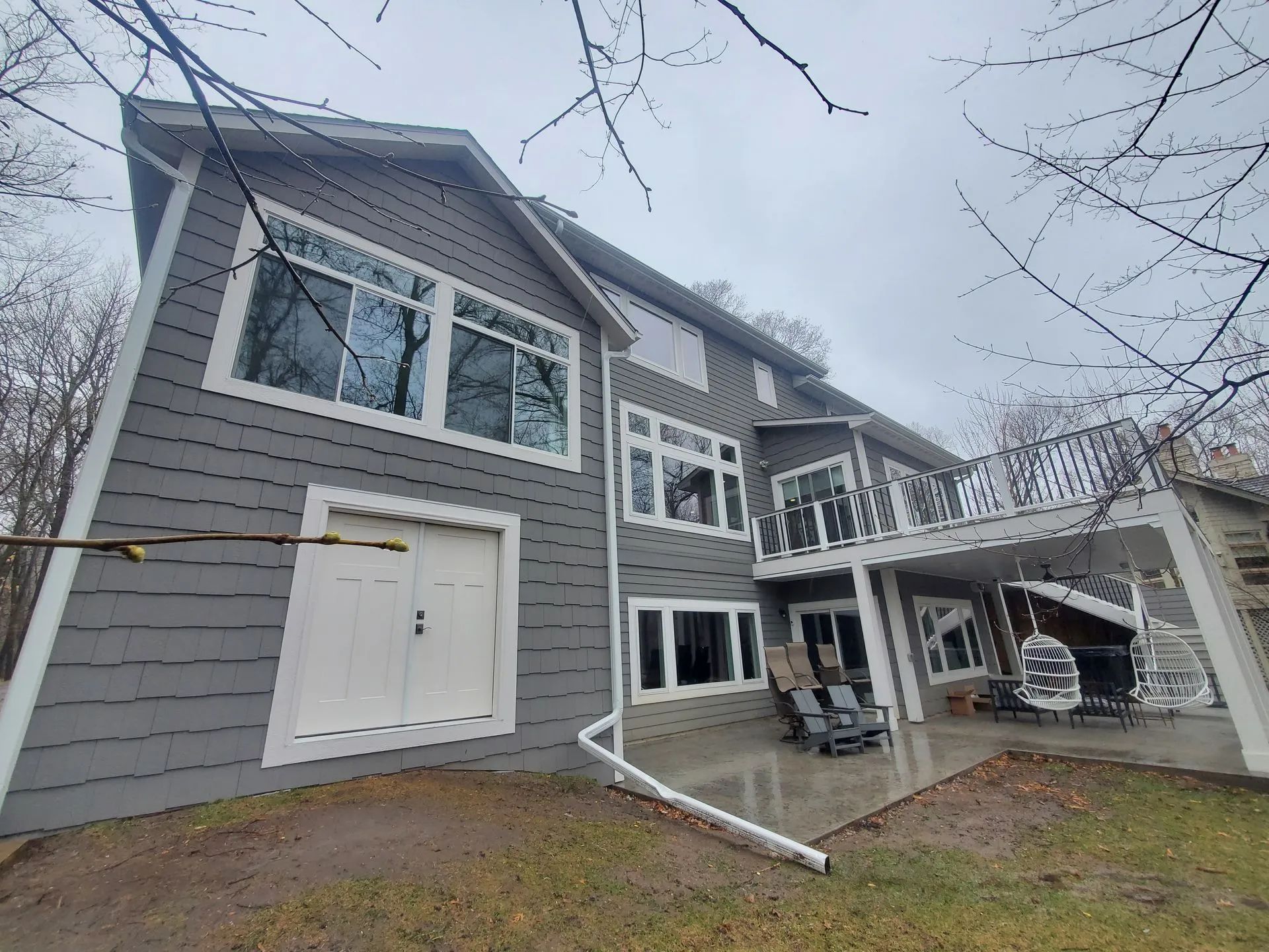 A large house with a large deck and a lot of windows.