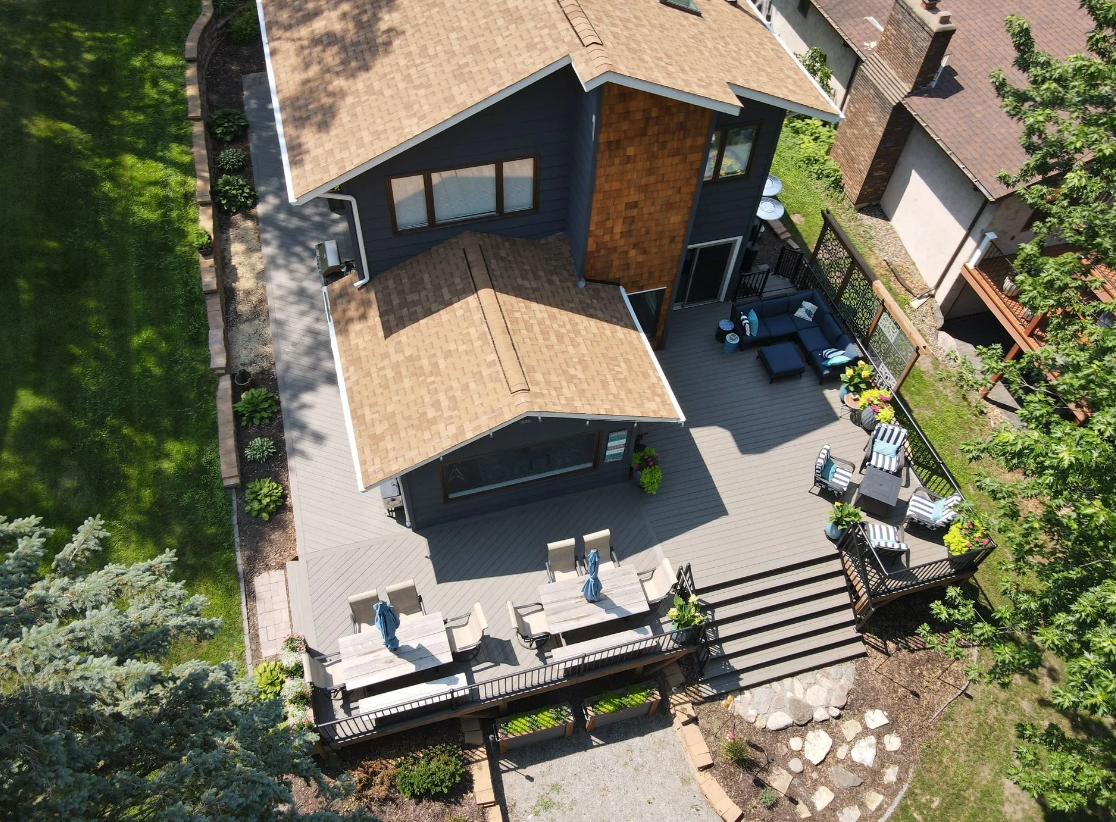 An aerial view of a house with a wooden deck and a pergola.