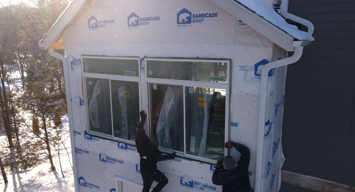 A man and a woman are installing a window in a room.